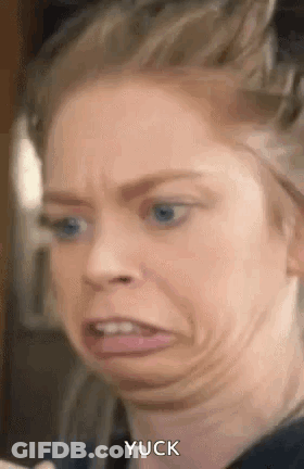 A Woman With Blue Eyes Is Making A Funny Face With Her Tongue Out . GIF