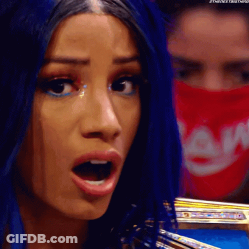 A Woman With Blue Hair And A Red Bandana On Her Face Is Making A Funny Face . GIF