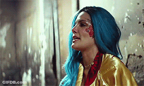 A Woman With Blue Hair And A Tattoo On Her Face . GIF