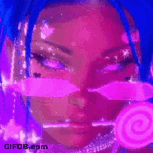 A Woman With Blue Hair And Pink Makeup Is Holding A Pink Lollipop In Her Hand . GIF