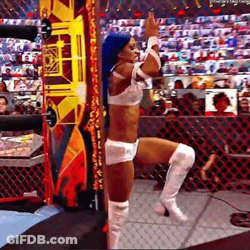 A Woman With Blue Hair And White Boots Is Standing In A Wrestling Ring With Her Leg Up . GIF
