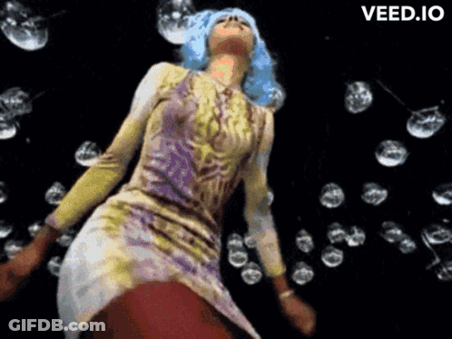 A Woman With Blue Hair Is Dancing In Front Of Bubbles And The Word Veed.io Is On The Bottom Right GIF