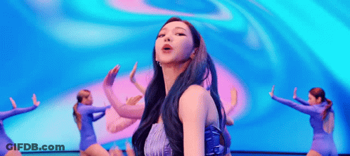 A Woman With Blue Hair Is Dancing On A Stage In Front Of A Crowd . GIF