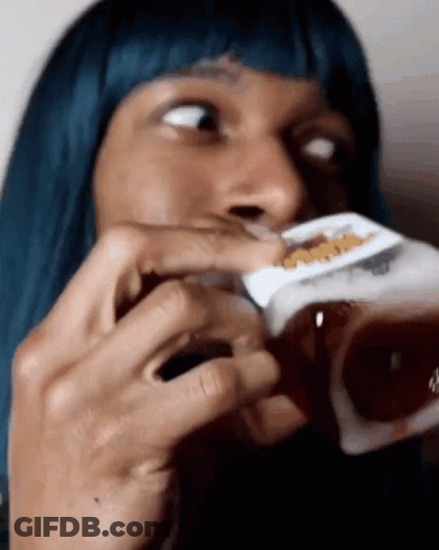 A Woman With Blue Hair Is Drinking From A Box Of Cereal GIF