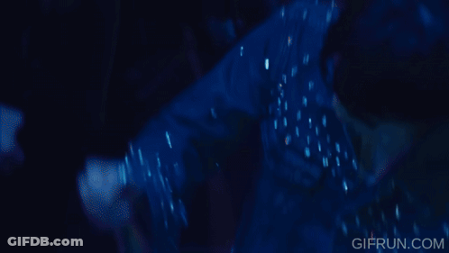 A Woman With Blue Hair Is Holding A Stack Of Champagne Glasses .. GIF