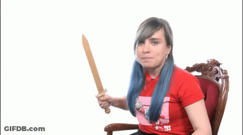 A Woman With Blue Hair Is Holding A Wooden Sword And Wearing A Red Shirt That Says T3 GIF