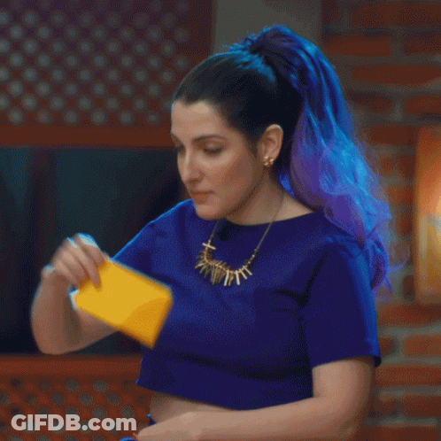 A Woman With Blue Hair Is Holding A Yellow Card In Her Hand GIF