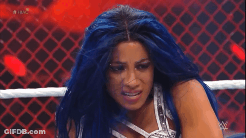 A Woman With Blue Hair Is In A Wrestling Ring With The Hashtag #Hug On The Screen GIF