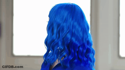 A Woman With Blue Hair Is Looking Out A Window . GIF