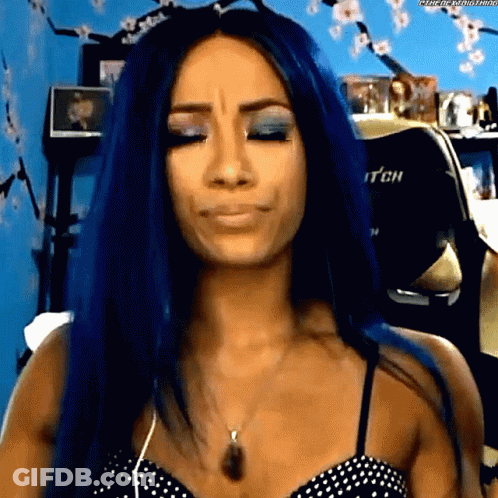A Woman With Blue Hair Is Making A Funny Face While Wearing A Polka Dot Top . GIF
