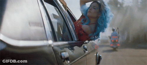 A Woman With Blue Hair Is Sitting In A Car . GIF