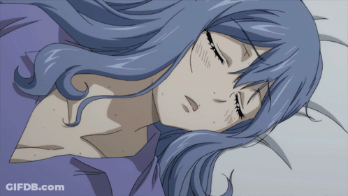 A Woman With Blue Hair Is Sleeping On A Bed With Her Eyes Closed GIF