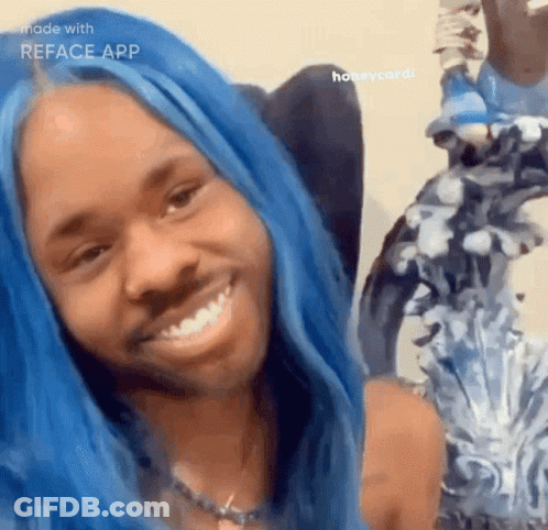 A Woman With Blue Hair Is Smiling In Front Of A Mirror GIF