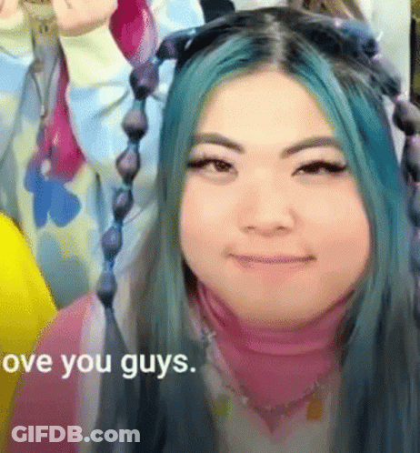 A Woman With Blue Hair Is Smiling With The Words " Love You Guys " In The Corner GIF