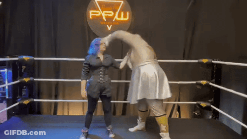 A Woman With Blue Hair Is Standing In A Wrestling Ring With A Sign That Says Pw GIF