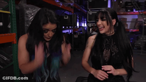 A Woman With Blue Hair Is Talking To Another Woman GIF
