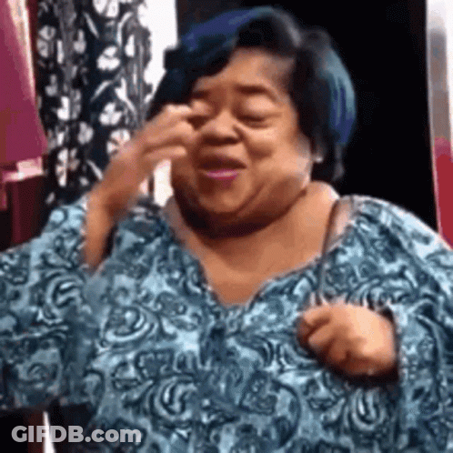 A Woman With Blue Hair Is Wearing A Blue Shirt And Making A Face . GIF