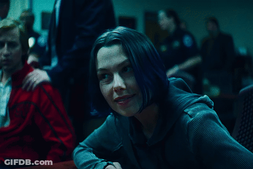 A Woman With Blue Hair Sits At A Table With A Man In A Red Jacket GIF
