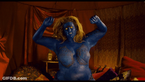 A Woman With Blue Paint On Her Face And Body Is Flexing Her Muscles GIF