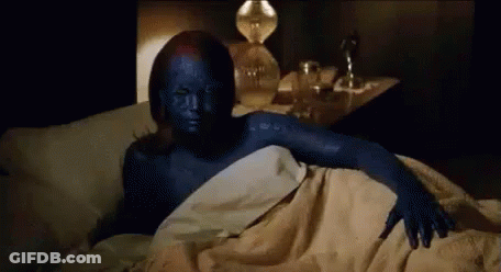 A Woman With Blue Paint On Her Face Is Laying In Bed . GIF