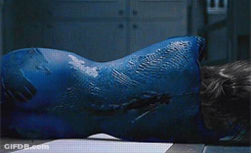 A Woman With Blue Paint On Her Face Is Laying On The Floor GIF
