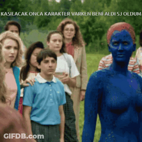 A Woman With Blue Paint On Her Face Is Standing In Front Of A Group Of People In A Field GIF