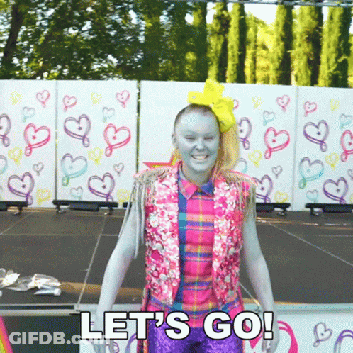 A Woman With Blue Paint On Her Face Is Standing On A Stage And Says Let 'S Go ! GIF