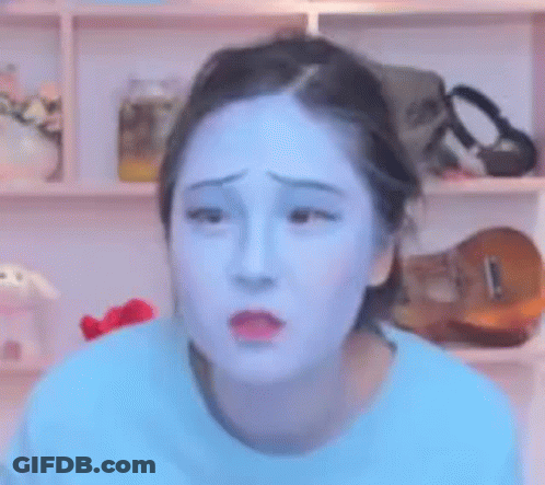 A Woman With Blue Paint On Her Face Looks Sad . GIF