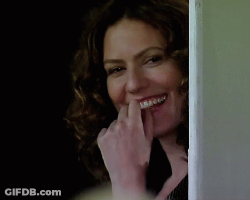 A Woman With Braces On Her Teeth Is Laughing GIF