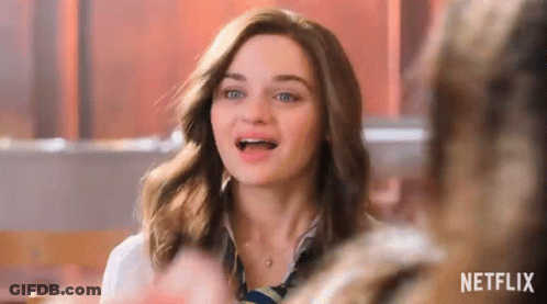A Woman With Braces On Her Teeth Is Sitting At A Table In A Restaurant . GIF