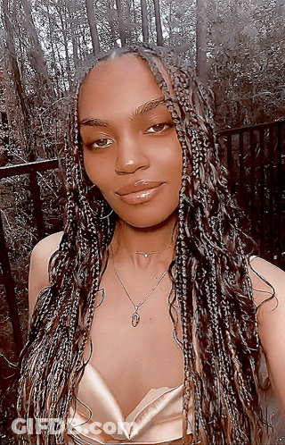 A Woman With Braids Is Wearing A Necklace GIF