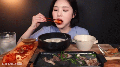 A Woman With Chopsticks Is Eating A Bowl Of Soup GIF