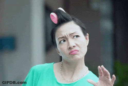 A Woman With Curlers In Her Hair Is Making A Face GIF