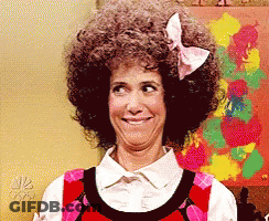 A Woman With Curly Hair And A Bow In Her Hair Is Smiling GIF