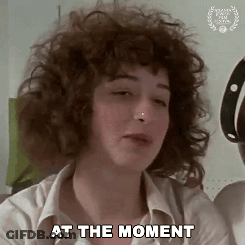 Woman With Curly Hair And Nose Ring Saying At The Moment GIF