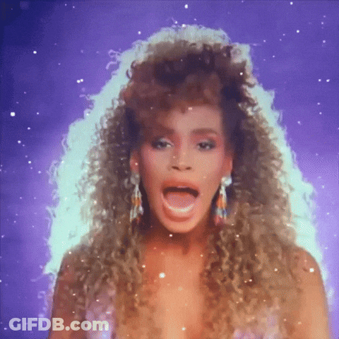 A Woman With Curly Hair And Earrings Is Singing GIF