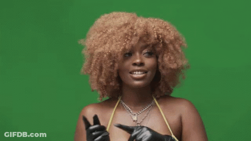 A Woman With Curly Hair And Gloves Is Giving A Thumbs Up Sign . GIF