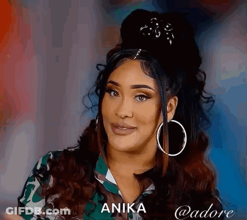 Woman With Curly Hair And Hoop Earrings Smiling In Camouflage Shirt GIF