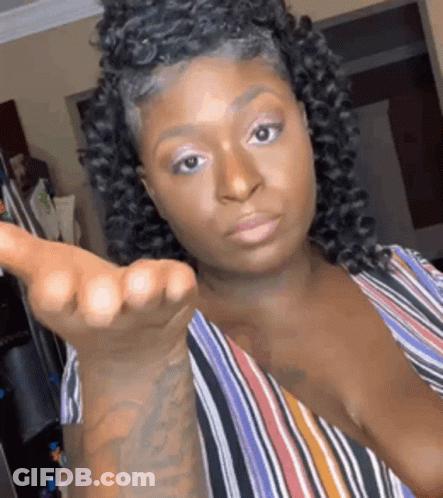 A Woman With Curly Hair Is Making A Funny Face And Giving A Middle Finger . GIF
