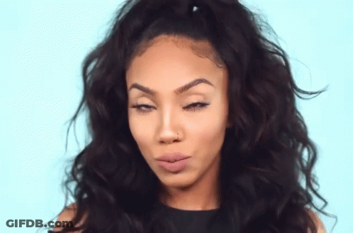 A Woman With Curly Hair Is Making A Funny Face With Her Eyes Closed . GIF