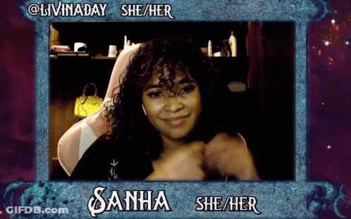 A Woman With Curly Hair Is Sitting In A Chair And Smiling In A Frame That Says Livinaday She / Her GIF