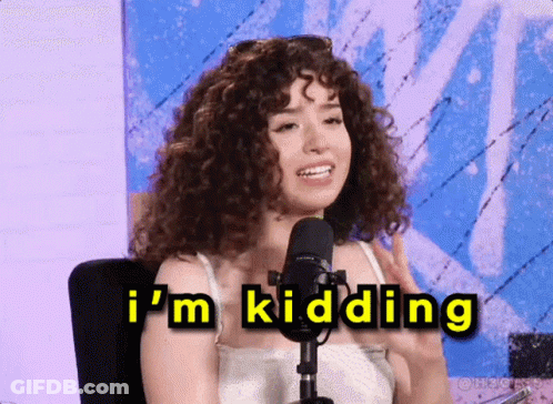 A Woman With Curly Hair Is Sitting In Front Of A Microphone And Says " I 'M Kidding " GIF
