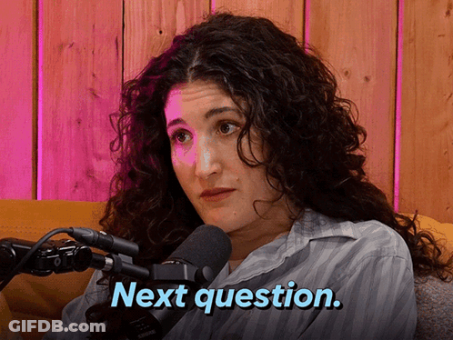 A Woman With Curly Hair Is Sitting In Front Of A Microphone And Says Next Question GIF