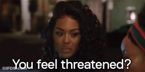 A Woman With Curly Hair Is Sitting Next To A Man . GIF