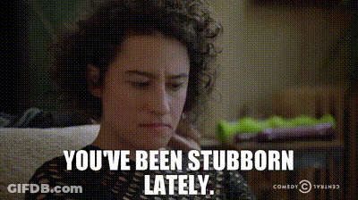 A Woman With Curly Hair Is Sitting On A Couch And Says You 'Ve Been Stubborn Lately .. GIF