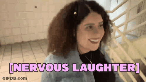 A Woman With Curly Hair Is Smiling And Says Nervous Laughter . GIF