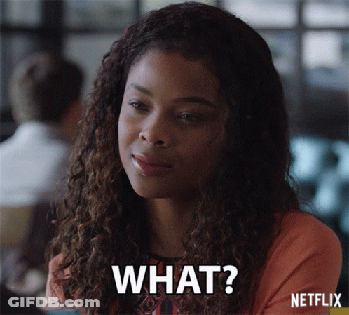 A Woman With Curly Hair Is Smiling And Says " What " GIF