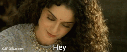 A Woman With Curly Hair Is Smiling And The Word Hey Is On The Bottom GIF