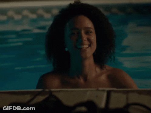A Woman With Curly Hair Is Smiling In A Pool GIF