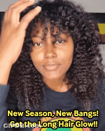 A Woman With Curly Hair Is Wearing A Blue Shirt That Says New Season New Bangs Get The Long Hair Glow !! GIF